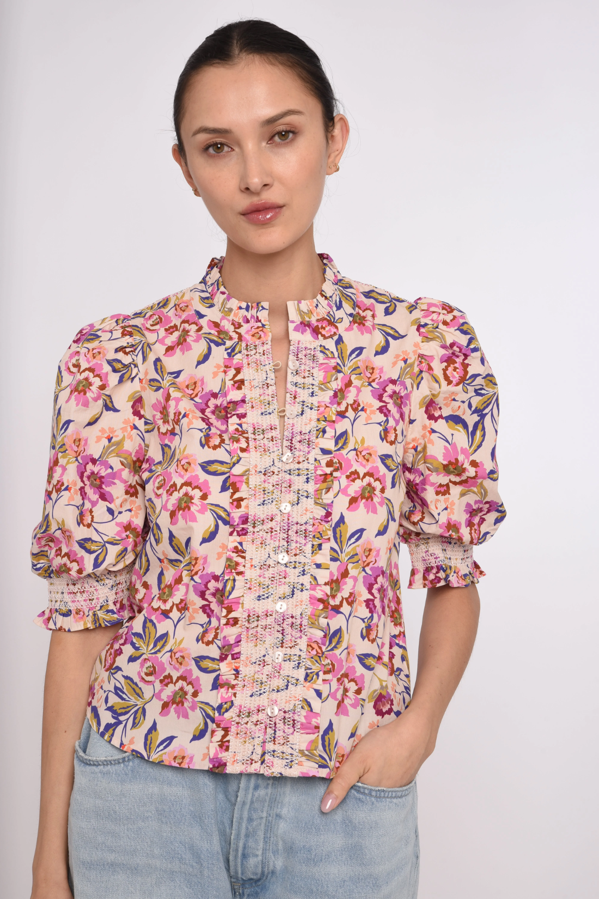 Woman wearing a floral blouse with puffed sleeves on a white background