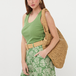 woman in green outfit and tote bag on white background 