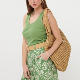 woman in green outfit and tote bag on white background 