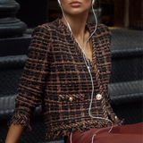 Model wearing a brown cardigan jacket with textured knit detailing and fringe accents.