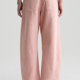 Person wearing pink wide-leg pants on a plain background