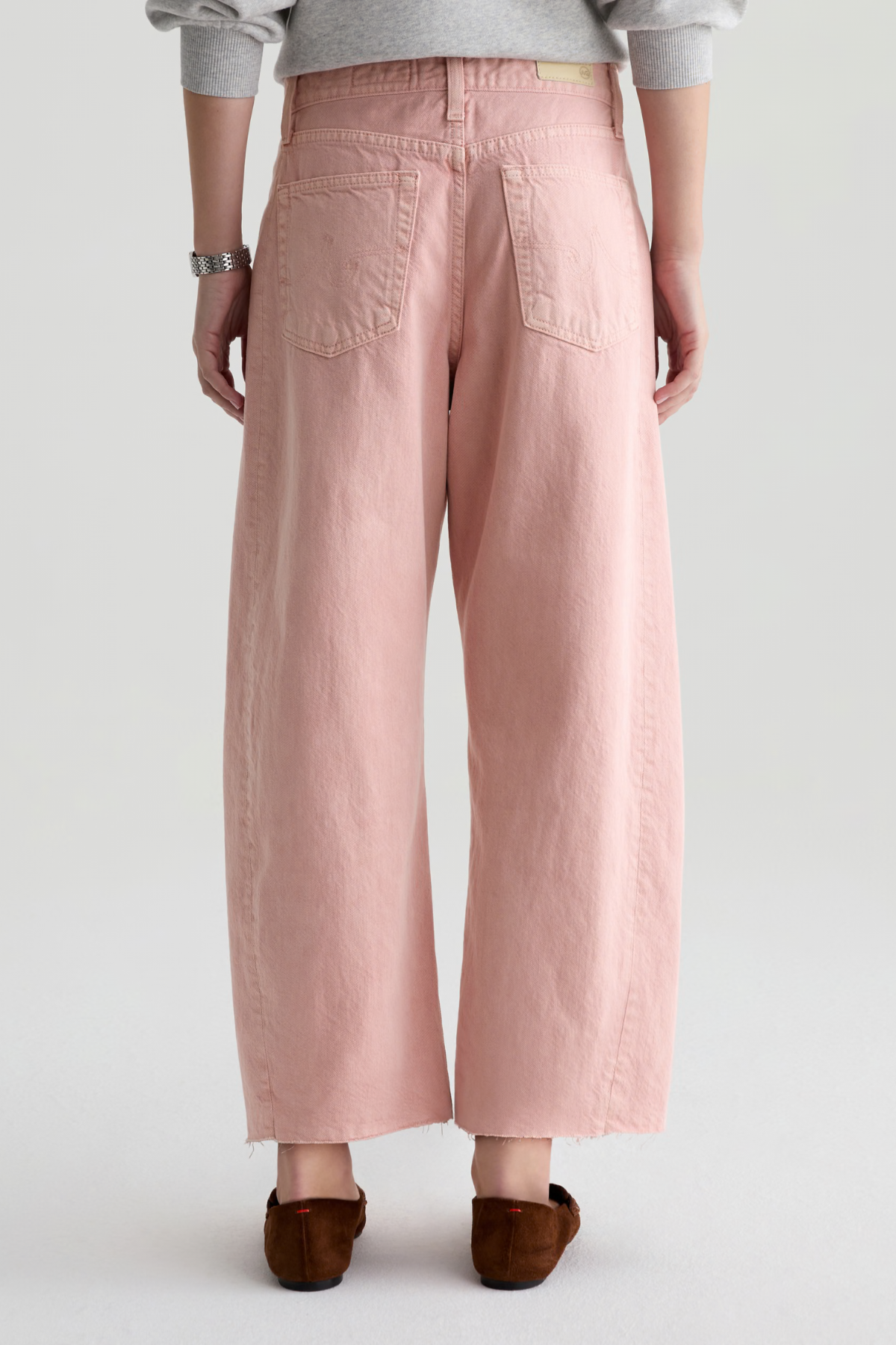 Person wearing pink wide-leg pants on a plain background