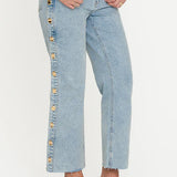 Light blue jeans with decorative buttons on a white background