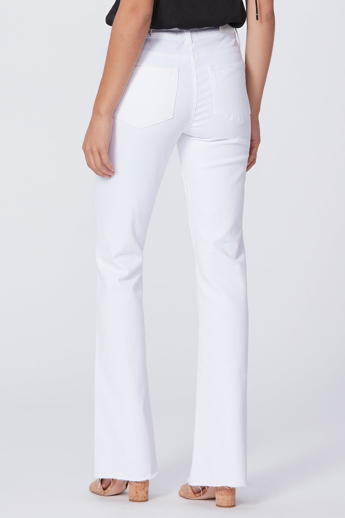 White pants worn by a person on a white background