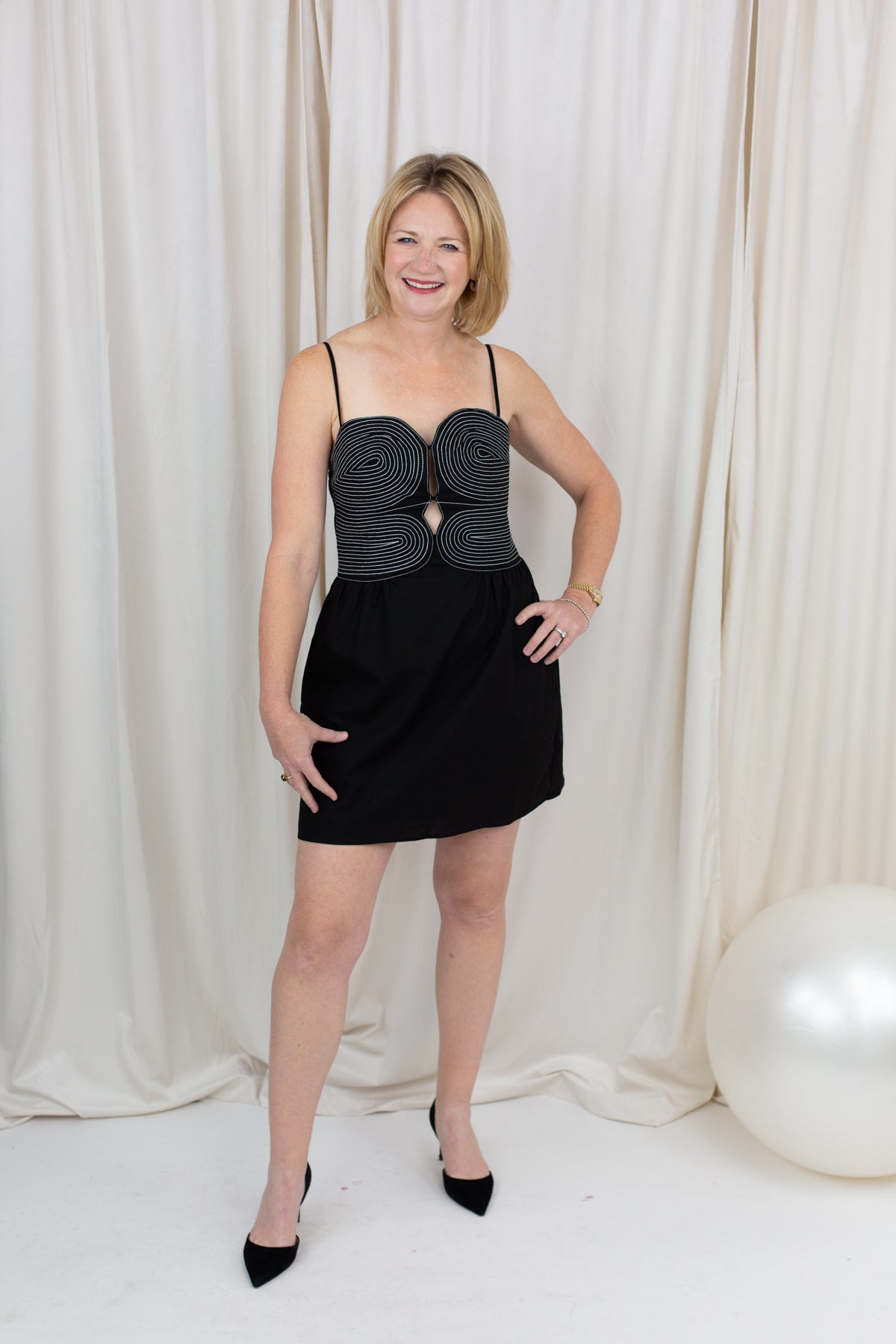 Black sleeveless bustier dress with top-stitch detailing, styled against a clean backdrop