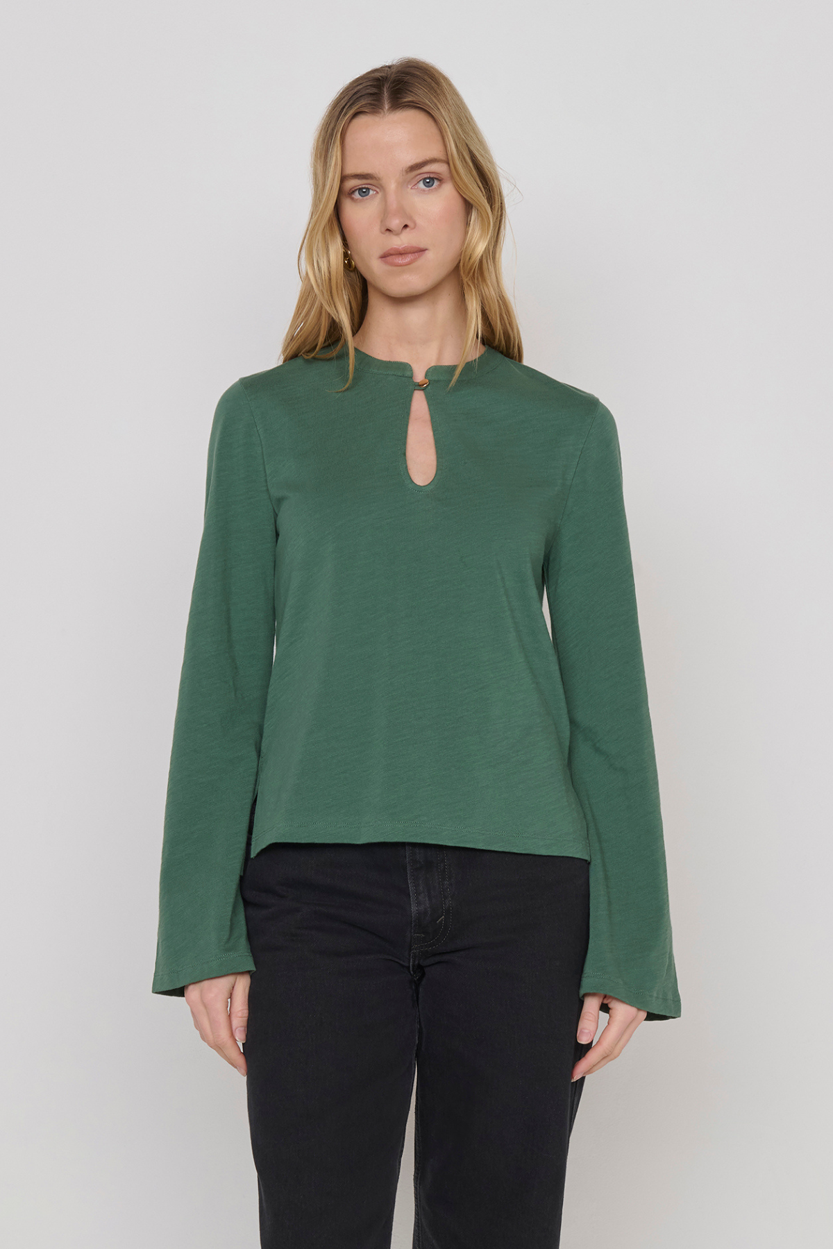 Women's green top featuring a keyhole neckline and feminine silhouette.