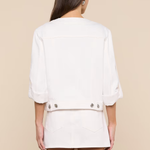 Person wearing a white outfit with a beige background