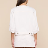 Person wearing a white outfit with a beige background