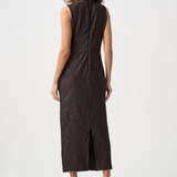 A woman shown from the back wearing a sleeveless dark brown midi dress with a textured crinkled fabric and a front slit, paired with black pointed-toe heels against a light gray studio background.