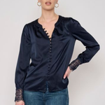 Model wearing a long-sleeve blouse with delicate lace detailing and a flattering tailored silhouette.