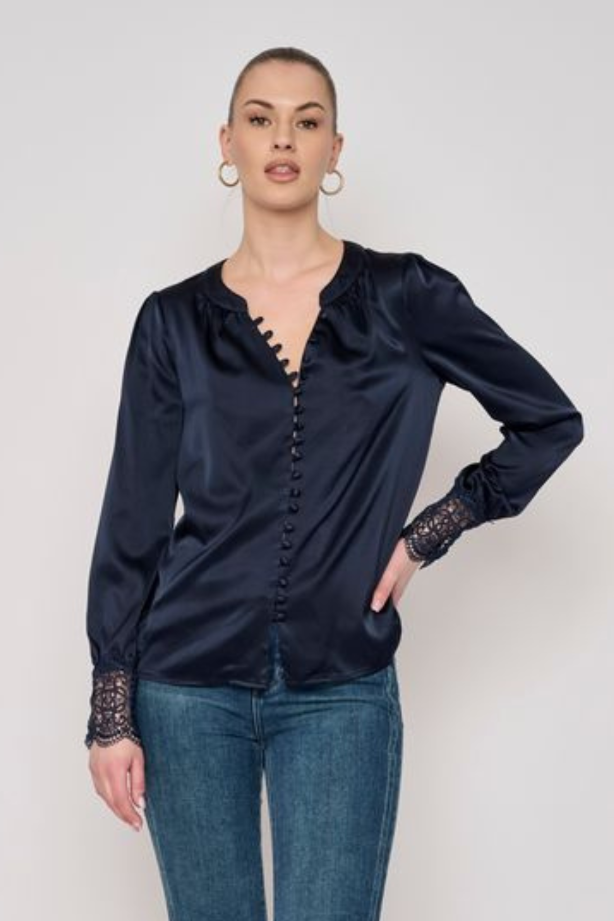 Model wearing a long-sleeve blouse with delicate lace detailing and a flattering tailored silhouette.