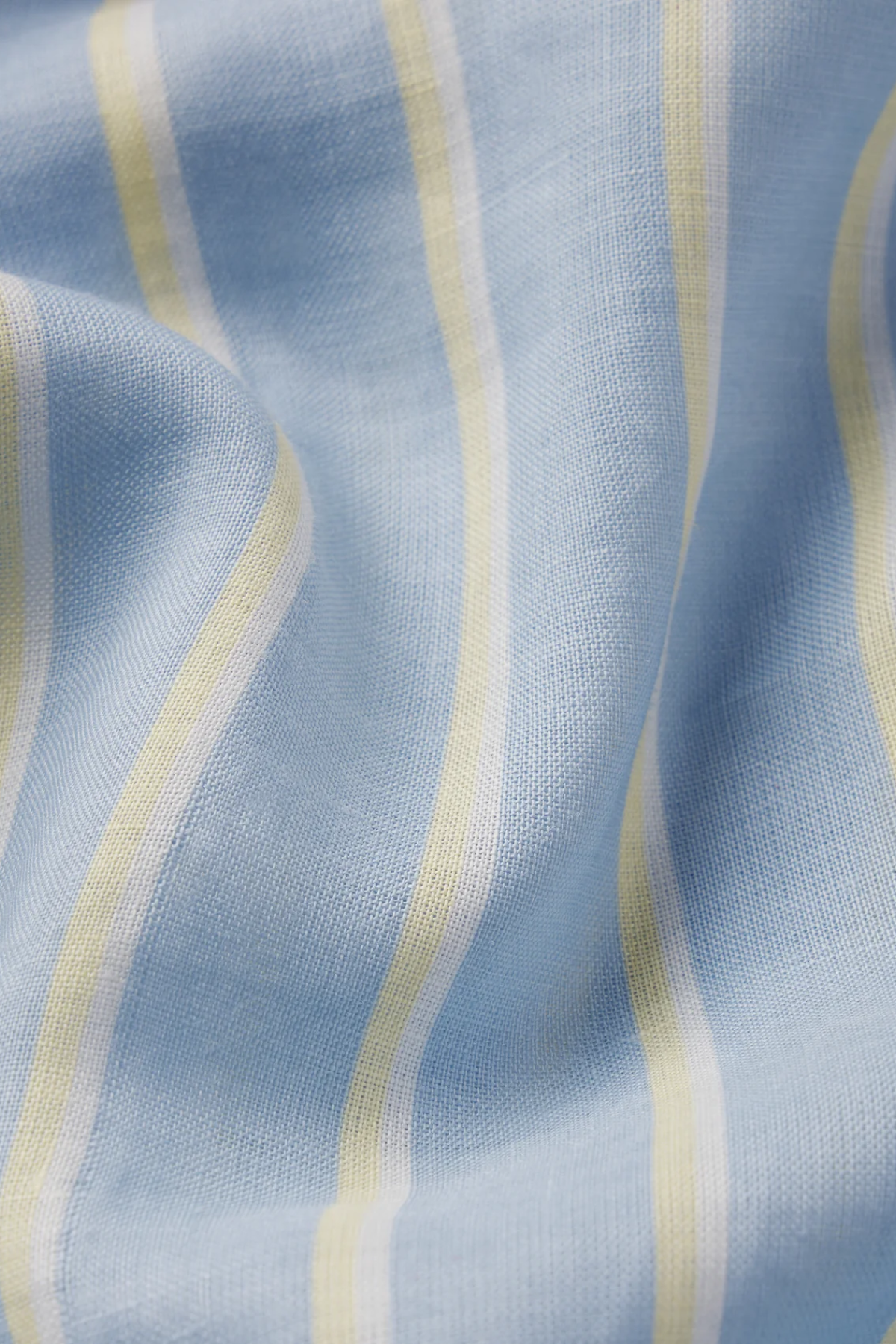 close up of white, blue and yellow striped fabric 
