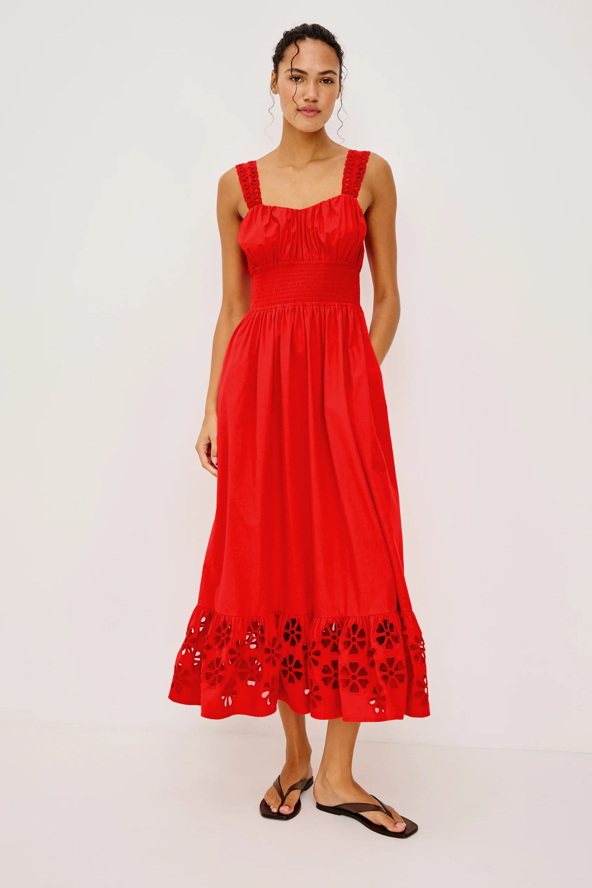Woman wearing a red dress with floral embroidery on a white background