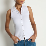Woman wearing a white sleeveless button-up shirt and blue jeans against a plain background