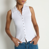 Woman wearing a white sleeveless button-up shirt and blue jeans against a plain background