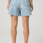 Light blue denim shorts worn by a person on a plain background