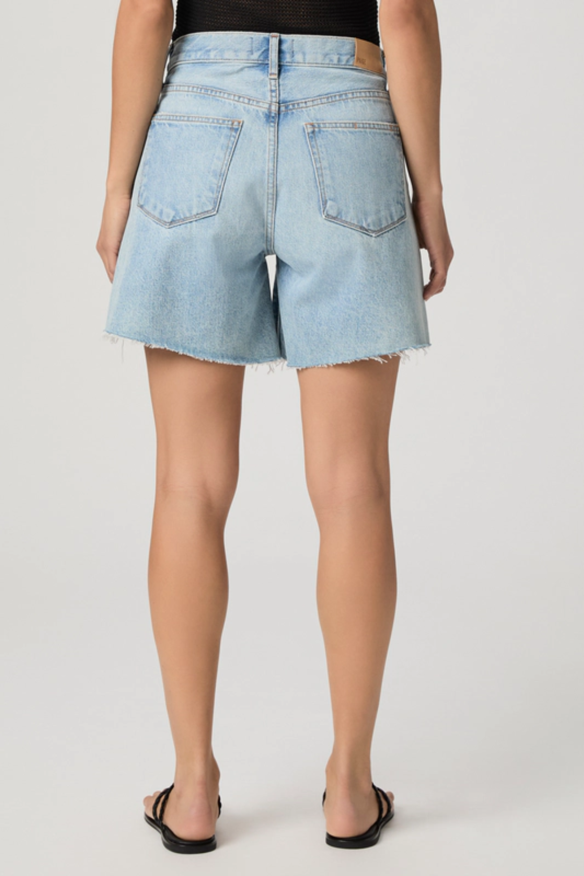Light blue denim shorts worn by a person on a plain background