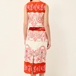 Woman wearing a red and white patterned dress on a white background