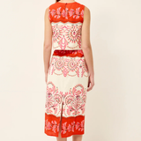 Woman wearing a red and white patterned dress on a white background