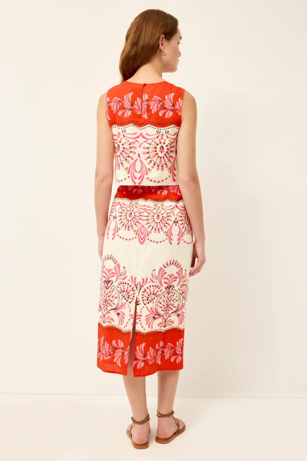Woman wearing a red and white patterned dress on a white background