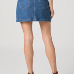 Denim skirt worn by a person on a plain background