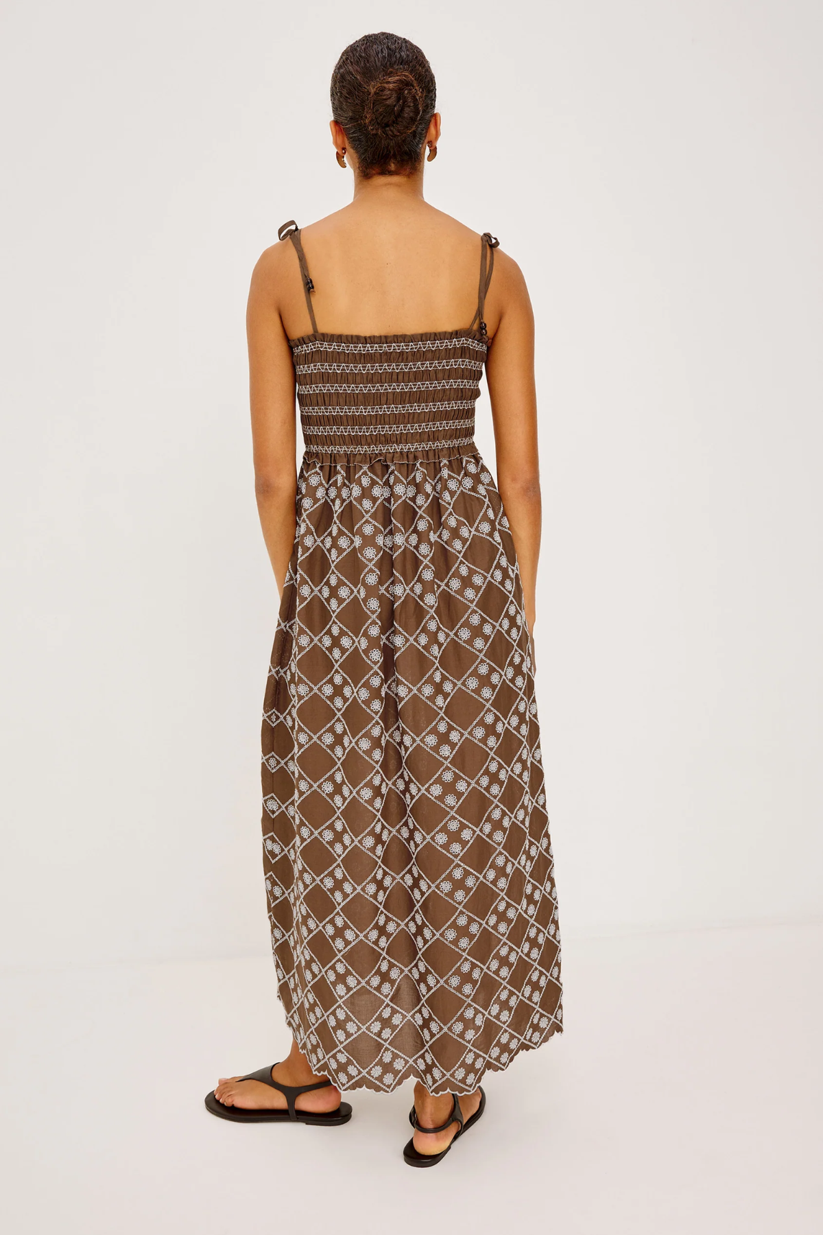 Woman wearing a patterned dress on a white background