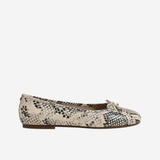 White sneaker with brown sole on a beige background