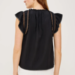 Woman wearing a black top with ruffled sleeves on a white background