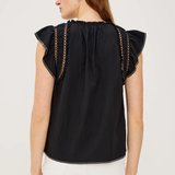Woman wearing a black top with ruffled sleeves on a white background
