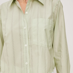 Light green button-up shirt worn by a person on a white background