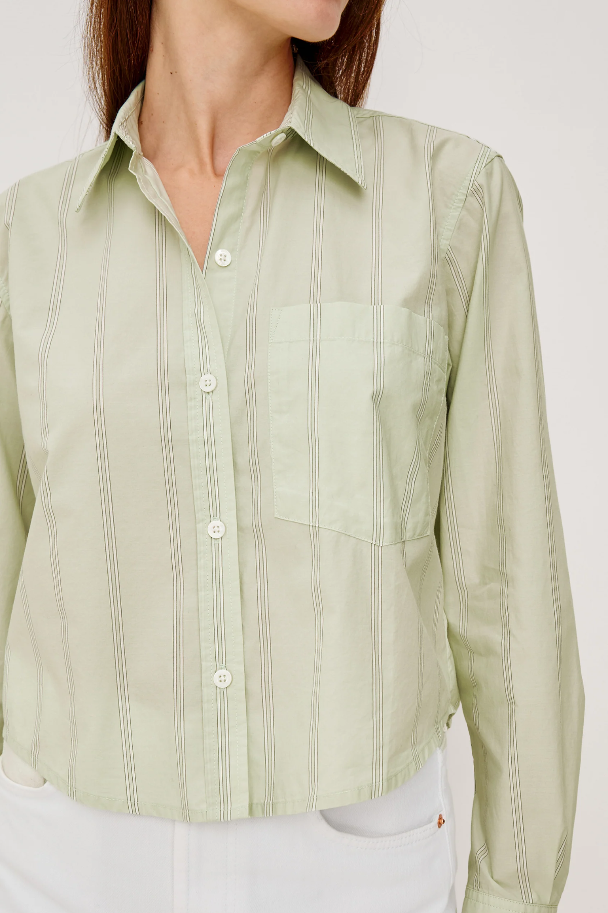 Light green button-up shirt worn by a person on a white background
