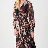 Woman wearing a long, patterned dress on a white background