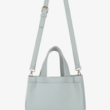 Light blue handbag with a matching strap on a white background