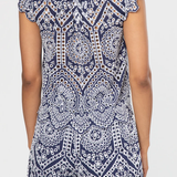 Navy and white patterned top with ruffled shoulders on a plain background
