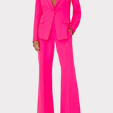 Bright pink suit with a blazer and flared pants on a white background