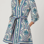 Woman wearing a patterned dress with a belt on a white background