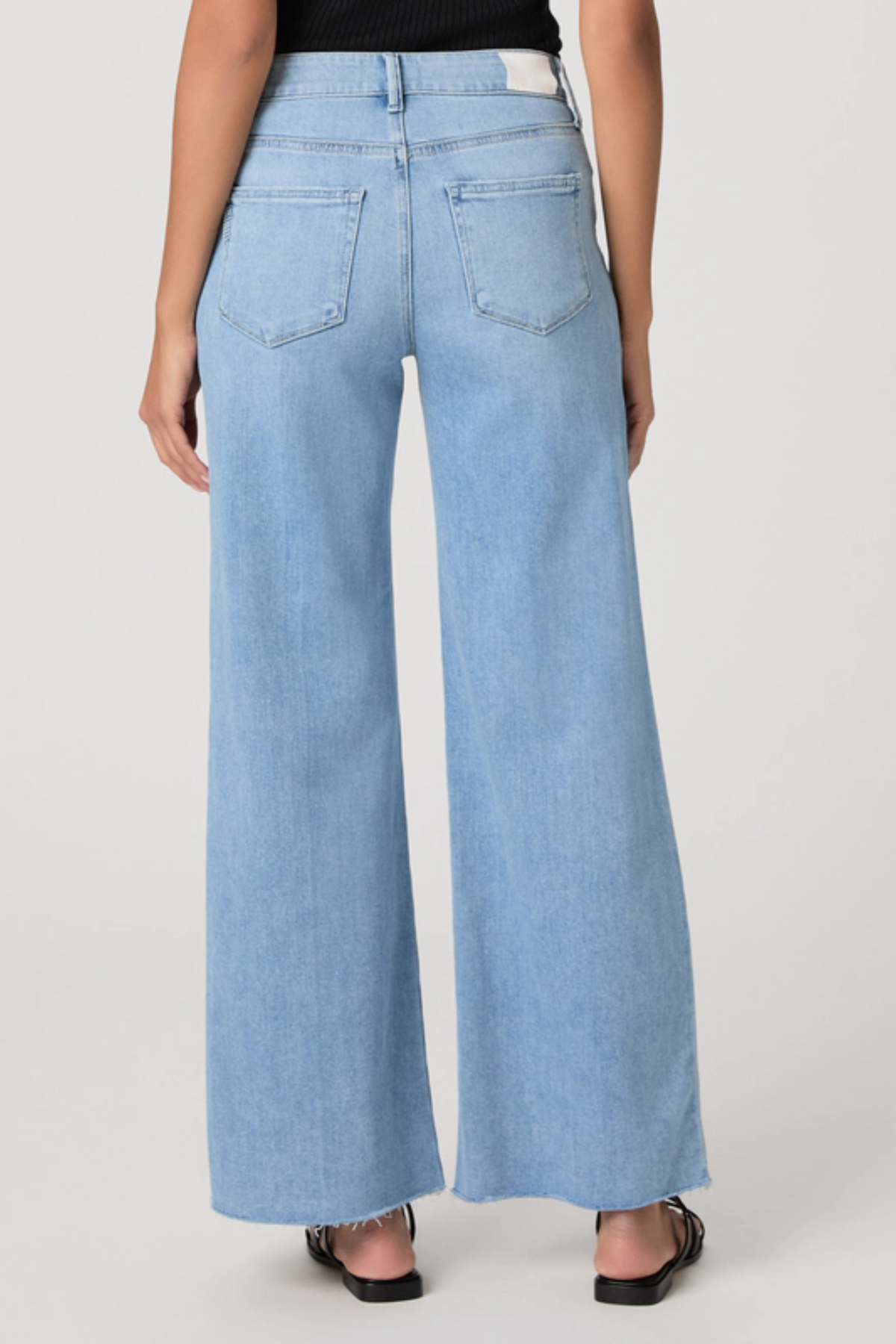 Light blue wide-leg jeans worn by a person on a white background
