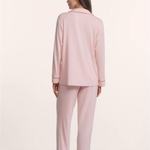 Woman wearing a pink pajama set on a white background