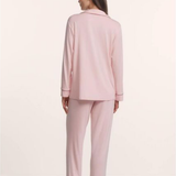 Woman wearing a pink pajama set on a white background