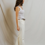 side view of woman in stripe tank and denim 