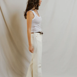 side view of woman in stripe tank and denim 