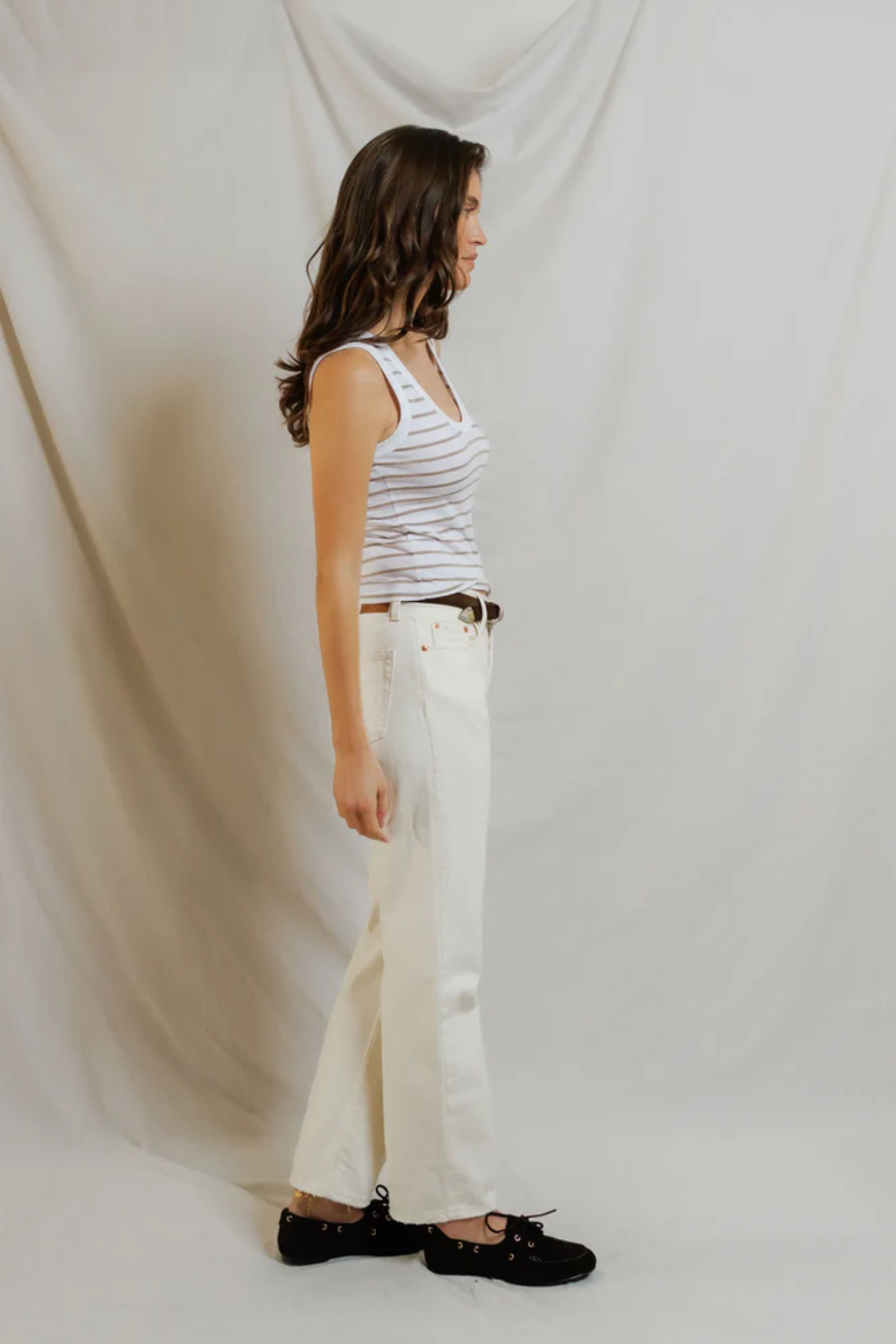 side view of woman in stripe tank and denim 
