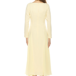 back of woman in butter yellow midi dress and long sleeves on white background 