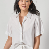 Woman wearing a white shirt against a plain background