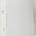 Close-up of a white button-up shirt with a blurred background