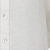 Close-up of a white button-up shirt with a blurred background