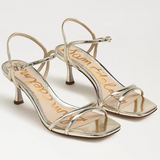 Pair of silver high-heeled sandals on a white background