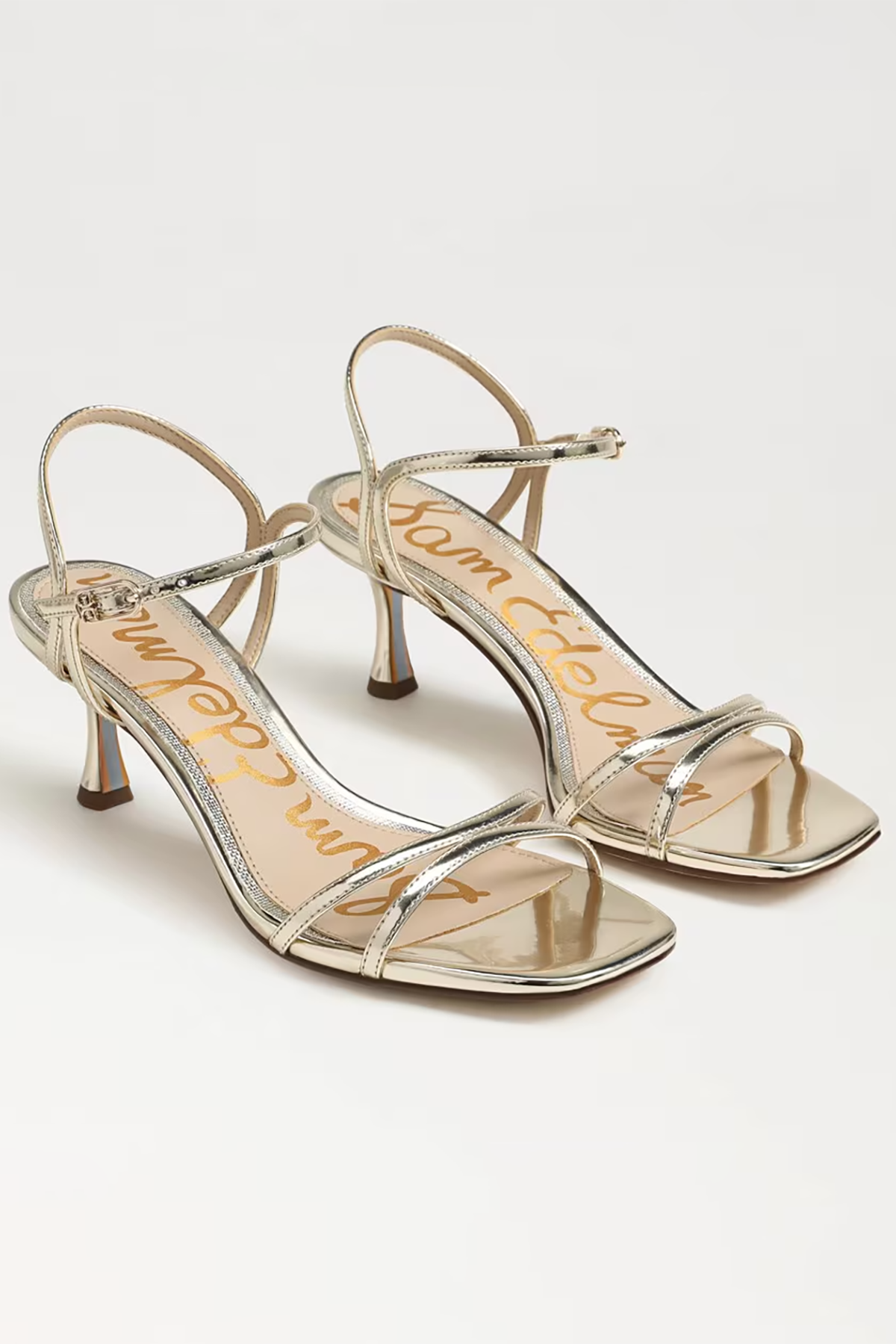Pair of silver high-heeled sandals on a white background
