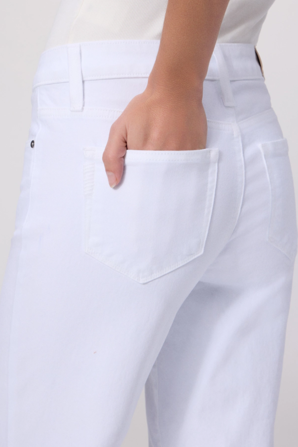 White pants with a pocket detail on a plain background