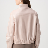 Woman wearing a beige jacket on a light gray background